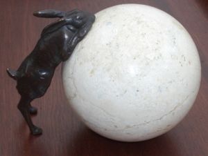 Rabbit leaning on sphere